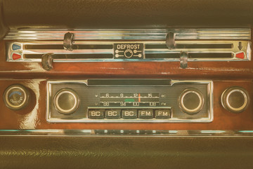Retro styled image of an old dashboard with seventies car radio