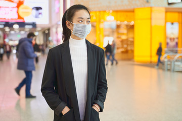 Alarmed female traveler of Asian appearance wears medical mask, afraid of infection. Deadly coronavirus in China 2019 2020 2019-nCoV. Free space for text or advertising.