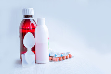 Orange thermometer and pills. Body temperature measurement. Normal human body temperature. Tablet vitamins, antiviral drugs and antibiotics. Mixtures and suspensions. A measuring bed.