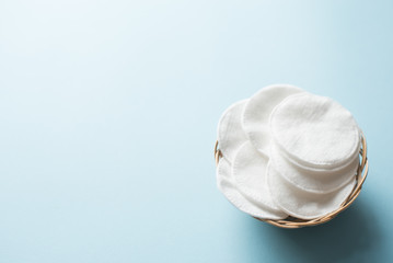Cotton pads on blue background copy space, flat lay. Several cotton pads for make-up. Close-up .