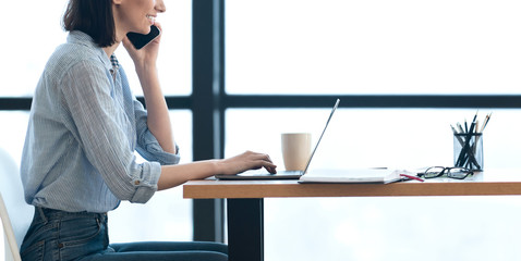 Smiling girl talking on the phone at office