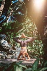 Real yoga. Full-length shot of caucasian woman standing in Headstand pose, Sirsasana while practicing yoga outdoors, in a garden. Healthy lifestyle and relaxation concept