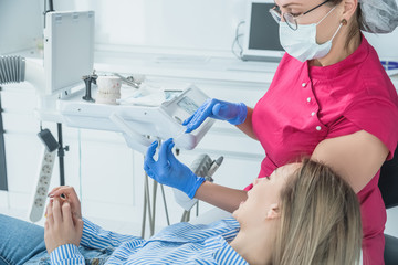 Female dentist doctor holds dental mouthguard in hands, splint therapy in dentistry to correct bite