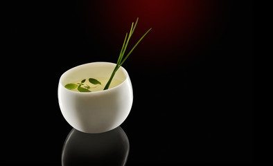 Asian gin cocktail in porcelain cup with garnish.