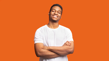Smiling afro guy portrait on orange background