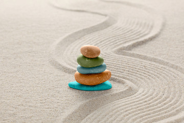 Fototapeta na wymiar zen stone concept, multi colors stones piled on the sand with copy space for your text