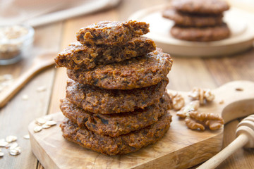 Healthy homemade cookie with oat flakes, dried fruits and seeds. Wooden rustic table.
