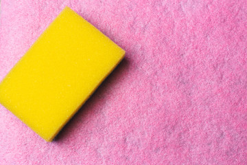 Yellow dishwasher sponge on a pink background