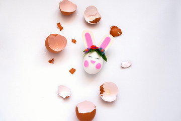top view flat lay brown eggs shell and cute bunny Easter egg on a white background