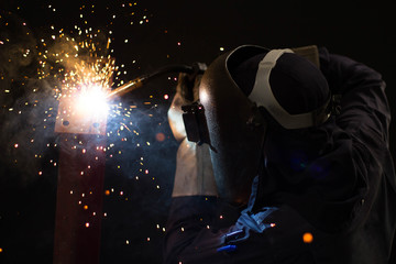Obraz na płótnie Canvas Metal workers use manual labor, Skilled welder, Factory workers making OT. Welder is welding the steel in the factory.
