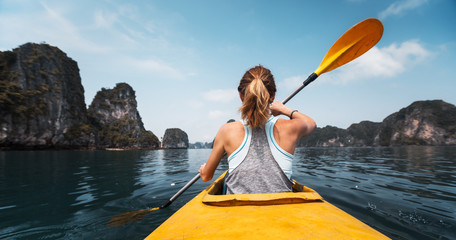Woman paddles kayak in the Ha Long Bay in Vietnam