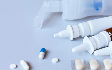 Medications in form of tablets, capsules, nasal sprays and inhalations on light table. Medical concept. Prevention and treatment of pneumonia, viral and coronavirus infections.  Close-up, copy space