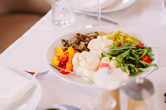 Delicious and useful food. Cheese balls Buratto, vegetables grill and fresh wares, greens.