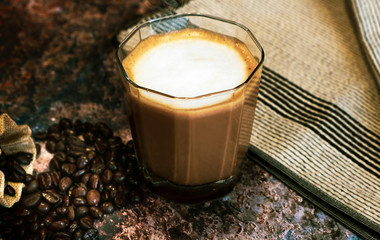 Hot latte coffee and coffee beans on metal floors