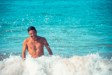 Young handsome man smiling in the sea.