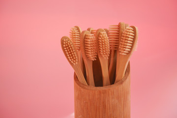 wooden bamboo toothbrushes on pink background