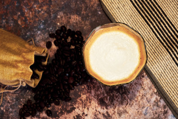 Hot latte coffee and coffee beans on metal floors