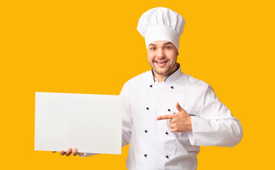 Chef Man Showing Empty White Board Standing Over Yellow Background