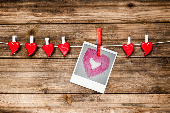 Red hearts and instant photo hanging on cord. Valentines Day card.