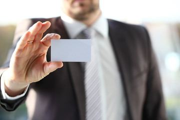 Male arm in suit give blank calling card to visitor closeup. White collar colleagues company name exchange job interview sale clerk id executive or ceo finance support formal identity concept