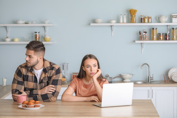 Upset young couple after quarrel in kitchen