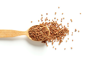 Spoon with raw buckwheat on white background