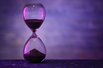 Hourglass on dark color background. Time management concept