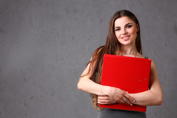 woman holding red folder in hand on gray background