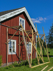 scaffolding on old red wooden house
