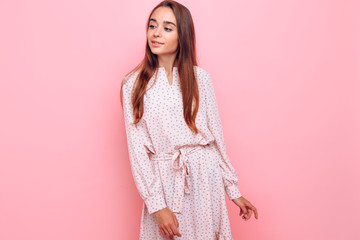Obraz premium Young woman in a stylish dress. Girl posing on a pink background