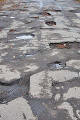 Old destroyed asphalt road with potholes and bumps