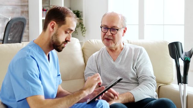 Caucasian male nurse talking with a nursing home intern about his health