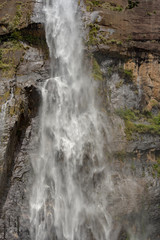 Sunny day in the Tropical waterfall falls from the mountain cliff to the jungle, serene landscape of Diyaluma falls.