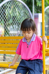Portrait of asian chcild girl sitting in park.