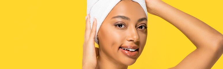 panoramic shot of smiling african american woman with towel on head, isolated on yellow