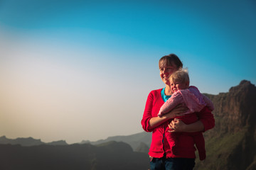 Naklejka na ściany i meble happy mother and cute little daughter travel in mountains