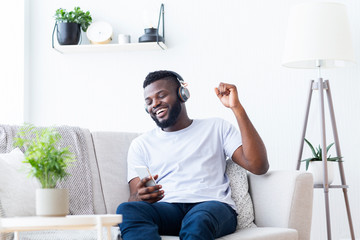 Millennial african american man in headphones enjoying music