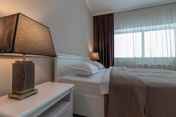 Bedroom. A bed with white clean linens with two lamps on the sides