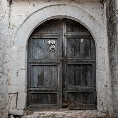 Fototapeta na wymiar Closed wooden door and stone wall in Berat, Albania