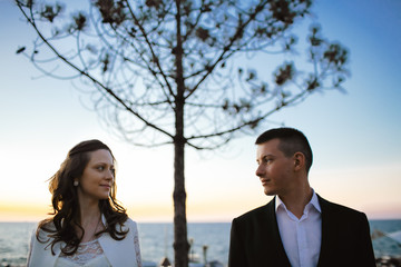 Couple standing separately and looking on each other eyes with picturesque lonely pine tree between...
