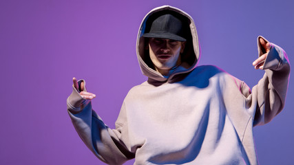 Modern Epic portrait of bboy in a neon light hoodie. Beneath the hood. Dark face. Mysterious and...