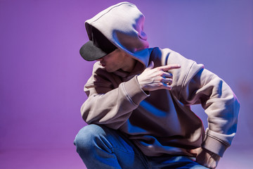 Modern Epic portrait of bboy in a neon light hoodie. Beneath the hood. Dark face. Mysterious and...