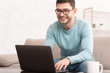 Freelancer Using Laptop Working Online Sitting On Sofa At Home