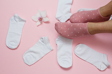 Women socks and female foots on pink background.