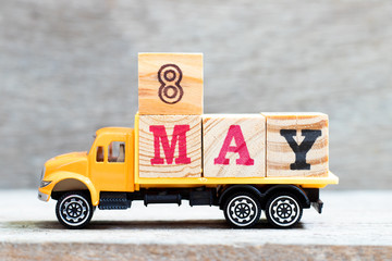 Truck hold letter block in word 8may on wood background (Concept for date 8 month May)