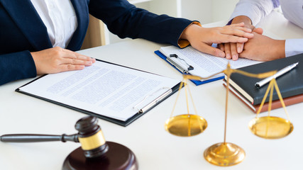 women attorney or lawyer provide holding hands to Consoling with client trust commitment  in...