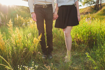 Fototapeta na wymiar Young couple holding hands. Girl and guy in nature. Love