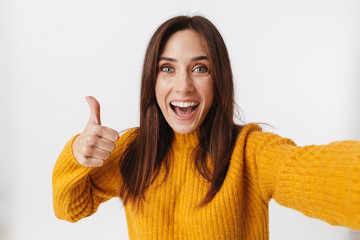 Image of adult woman smiling and taking selfie photo with thumb up