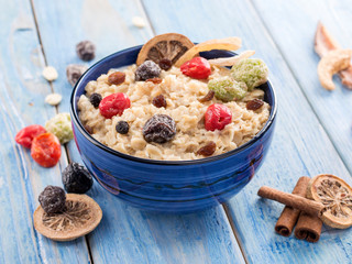 oatmeal with dried fruits on a blue wooden background
