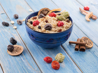 oatmeal with dried fruits on a blue wooden background